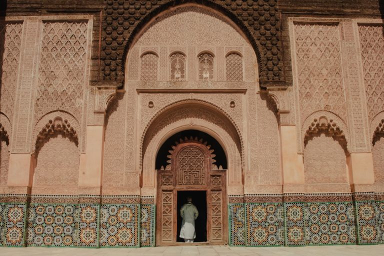 Riad doorway in the Marrakech médina, traveller stepping into the courtyard